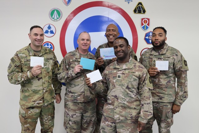 Five of the 135 Soldiers of the 135th Expeditionary Sustainment Command, Alabama National Guard, hold their birthday cards for the last known surviving Tuskegee Airman, Sgt. Victor Butler, who turns 100 May 21, 2022. Left to right: Sgt. 1st Class Brian Lynd, Lt. Col. Joel Traweek, Sgt. 1st Class Willie Vandiver, Capt. Jeremy Barrett, and Sgt. 1st Class Carnard McCalpine.
