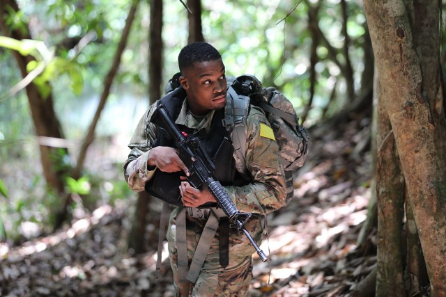 Spc. Donell Warner, assigned to Public Health Command-Pacific, takes part in the mystery event during the Regional Health Command-Pacific Best Leader Competition, May 9, 2022. During the mystery event, competitors had to treat a simulated casualty in jungle conditions and transport the ‘patient’ downstream on a raft made from competitors’ rucksacks. Here, Warner provides security for his teammates.
