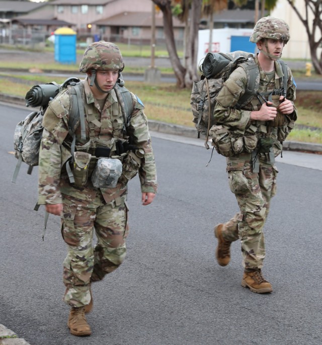 Sgt. Michael Charbonneau, left, and Spc. Gavin Byorick, both assigned to U.S. Army Medical Department-Korea, step out on a five-mile road march during the Regional Health Command-Pacific Best Leader Competition, Schofield Barracks, Hawaii, May 10, 2022.