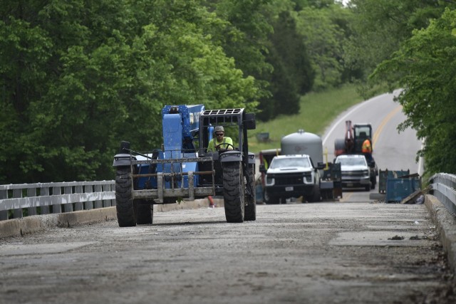 Workers continue to install safety equipment on the bridge outside the East Gate May 19, before old paint and concrete can be removed. The gate is scheduled to open in January 2023, after improvements are made to the bridge that connects J Highway to Fort Leonard Wood. 