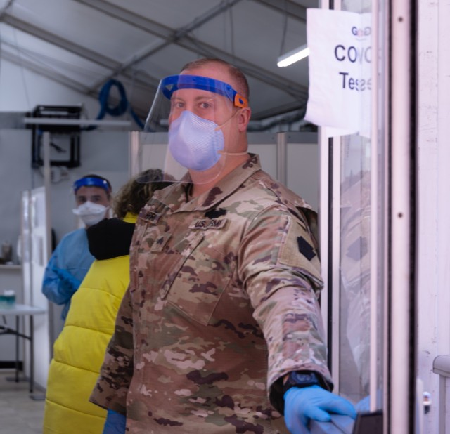 Sgt. Robert Harris, a Soldier with the 1-175 Infantry Regiment, Maryland Army National Guard, assisted community members at the Anne Arundel Medical Center in Annapolis, Maryland, on February 2, 2022, with an open door and a friendly greeting as individuals made their way through the testing tent. At the direction of Gov. Larry Hogan, up to 1,000 MDNG members were activated to assist state and local health officials with their COVID-19 response to include the distribution of COVID-19 test kits, 20 million KN95 and N95 masks, and other personal protective equipment and to provide support to skilled nursing facilities, hospitals, and testing sites.(U.S. Army National Guard Photo by Staff Sgt. Elise Moore).