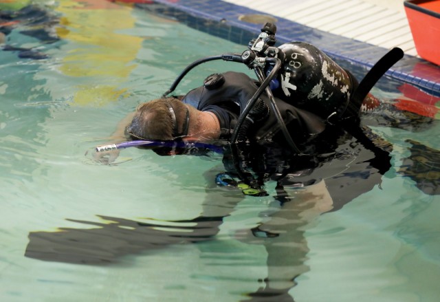 Petty Officer 1st Class Westley Gorman, a Navy hospital corpsman assigned to the Defense POW/MIA Accounting Agency at Joint Base Pearl Harbor-Hickam, Hawaii, tests his mask seal and breathing apparatus in the pool at Naval Station Everett, Washington, during the Joint Hyperbaric Medical Officer and Technician Course, April 26, 2022.