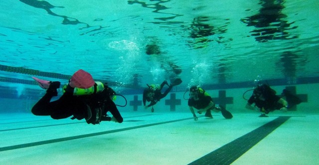 A group of students in the Joint Hyperbaric Medical Officer and Technician Course, some wearing dive equipment for the first time, take to the pool at Naval Station Everett, Washington, April 26, 2022.