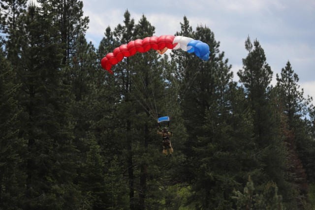 An experienced smokejumper expertly avoids trees to make a soft landing in a field.