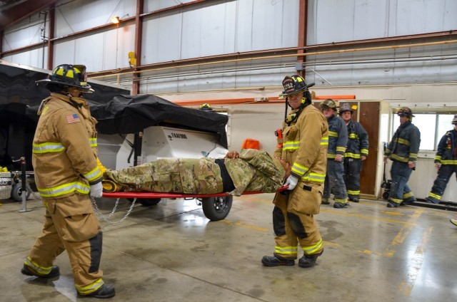 Fort Leonard Wood firefighters carry a mock-casualty May 25 at Forney Airfield during an installation-wide integrated protection exercise. 