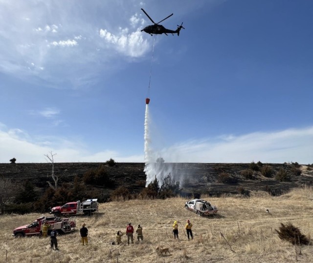 A Nebraska Army National Guard UH-60 Black Hawk helicopter drops water from a 780-gallon bucket onto a smoldering hot spot near Arapahoe, Nebraska, April 9, 2022. National Guard units throughout the nation have been fighting wildfires already, before the traditional start of the wildfire season in June. (U.S. Army National Guard photo by Capt. Joshua Pryor) 
