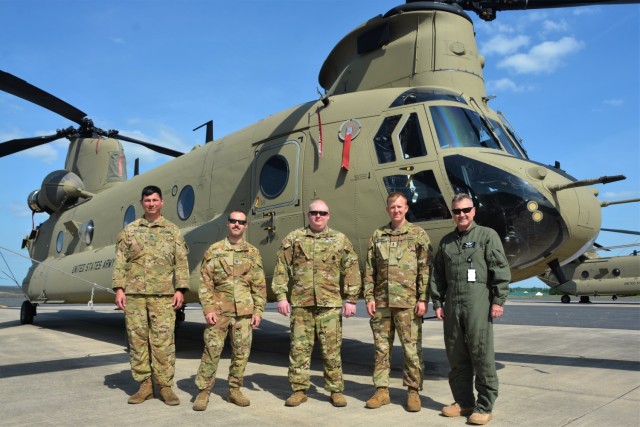 Left to right, Staff Sgt. Kyle Waller of the Illinois National Guard’s Company B, 238th General Support Aviation Battalion; Staff Sgt. Anthony Bearoff of the Pennsylvania National Guard’s Company B, 2-104th General Support Aviation Battalion; Staff Sgt. Robert Prigel, an instructor at the Eastern Army National Guard Aviation Site; Chief Warrant Officer 4 Kyle Kephart and Ron Henry, instructor pilots at EAATS, in front of a CH-47 Chinook helicopter on Muir Army Airfield at Fort Indiantown Gap, Pa., May 25, 2022. (Pennsylvania National Guard photo by Brad Rhen) (This photo was altered to obscure an ID card)