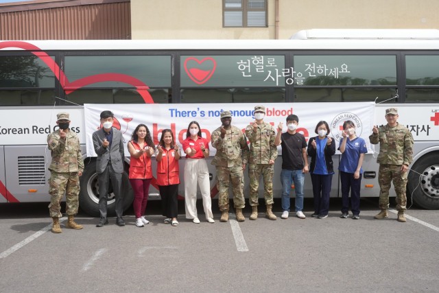 Members of the 65th Medical Brigade, Korean National Red Cross and American Red Cross pose for a group photo outside a blood donation vehicle at Camp Walker, Republic of Korea, May 10, 2022. Members of the U.S. Army Garrison Daegu community donated approximately 43 liters of blood during the month of May.