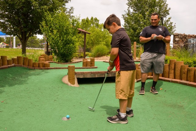 Staff Sgt. Michael Long, with Company A, 2nd Battalion 10th Infantry Regiment, watches his son, Troy, sink a putt at the Fort Leonard Wood Rec Plex’s mini-golf course today. The Directorate of Family and Morale, Welfare and Recreation opened the Rec Plex for the 2022 season on Saturday. 