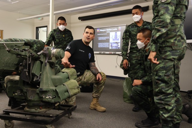 Staff Sgt. Travis Mattoon, Stryker Leaders' Course instructor from 1st Battalion, 205th Regional Training Institute, Washington Army National Guard, instructs Royal Thai Army officers on the remote weapons system of a Stryker combat vehicle....