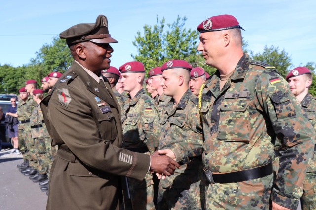 Col. Mark Denton, commander, 207th Military Intelligence Brigade – Theater, meets with soldiers from the German Army during a ceremony that commemorates and honors the men of Easy Company, 506th Parachute Regiment, 101st Airborne Division who lost their lives when their C-47 aircraft was hit by enemy fire in June of 1944, Sainte Mere Eglise, Normandy, France, June 2.