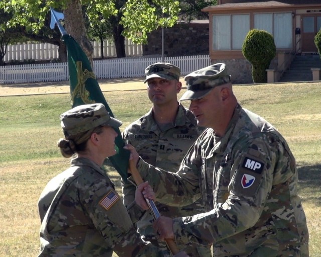 (right) Maj. Joshua Donecker, Executive Officer, U.S. Army Garrison-Fort Huachuca passes the unit guidon to Capt Traci Beri, Incoming Commander, 18th Military Police Detachment, and 483 Military Working Dog Detachment as Capt Anthony Gardull, Outgoing Commander, 18th Military Police Detachment and 483 Military Working Dog Detachment looks on at Fort Huachuca, Ariz.