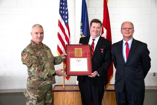 Kentucky National Guard veteran Sgt. John Burlew receives a framed copy of his Bronze Star Medal with Valor certificate from Kentucky National Guard Adjutant General Haldane Lamberton with U.S. Representative Brett Guthrie present at the Owensboro...