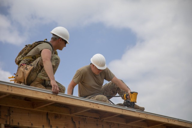 Two Oklahoma National Guard Soldiers place and nail trim on one of seven houses being built at the Innovative Readiness Training construction site in Tahlequah, Oklahoma, June 6, 2022. Construction is being completed for the IRT Cherokee Veterans Housing Initiative, which is a multi-year project that allows Guardsmen and Reservists from the Marines, Army, Navy and Air Force to build homes each year for Cherokee Veterans. (Oklahoma National Guard Photo by Pfc. Haden Tolbert)