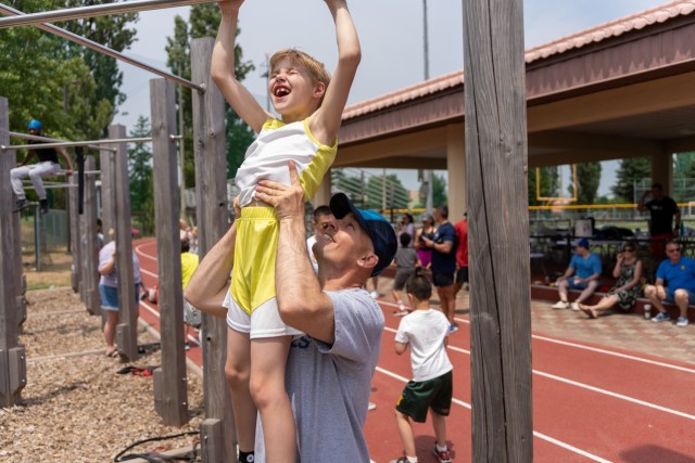 Almost there—a young participant in the Lil Murph Challenge gets some assistance with a pull-up at Camp Walker, Republic of Korea, June 4, 2022. The Lil Murph Challenge is a U.S. Army Garrison Daegu fitness event for children (ages 5-11) held to honor the sacrifice of Lt. Michael P. Murphy, a Medal of Honor recipient.