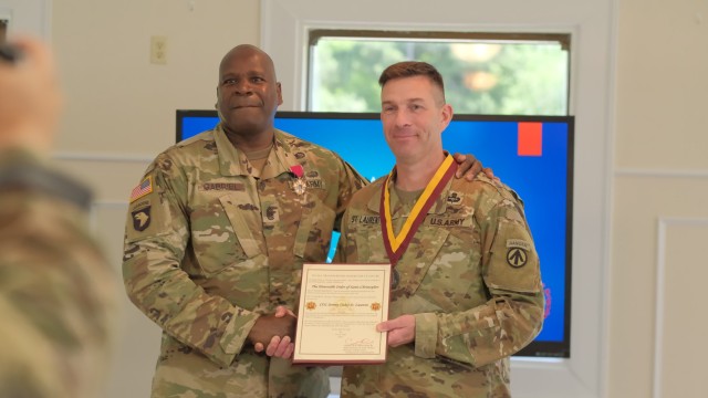 Command Sgt. Maj. Lonnie Gabriel presents Jeremy St. Laurent, commander, 597th Transportation Brigade, the Honorable Order of Saint Christopher during a ceremony at the Fort Eustis Club at Joint Base Langley-Eustis, Va. June 9.