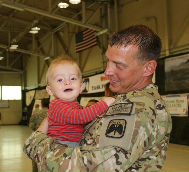 1st Sgt. James Rihn holds his son Adam after returning home from deployment to Afghanistan. 
