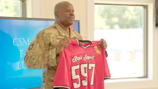 Command Sgt. Maj. Lonnie Gabriel posed with a Rapid Support shirt during a farewell luncheon at the Fort Eustis Club at Joint Base Langley-Eustis, Va. June 9.