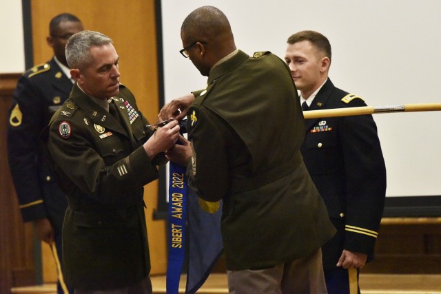 U.S. Army Chemical, Biological, Radiological and Nuclear School Commandant Col. Sean Crockett (left) and USACBRNS Regimental Command Sgt. Maj. Christopher Williams affix a streamer denoting the 2022 Sibert Award on the guidon of the 9th Chemical, Biological, Radiological, Nuclear and Explosive Company (Technical Escort), from Joint Base Lewis-McChord, Washington, during an awards presentation event Friday in Lincoln Hall Auditorium. Named after Maj. Gen. William Sibert — often referred to as the “Father of the Chemical Corps” — the annual award recognizes the top-performing CBRN companies in the active-duty Army, National Guard and Reserve, and the top-performing team or detachment. The 9th CBRNE Company won in the active-component category. 