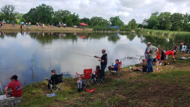 Fort Leonard Wood community members line the banks of the Training Area 228 pond during the Kid&#39;s Catfishing Derby on Saturday. Out of the 130 children who participated in the event, 11 were fishing for the first time. 
