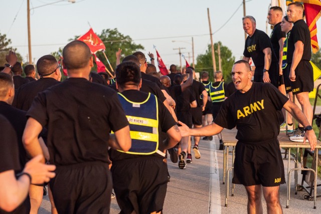 Maj. Gen. James Bonner, Maneuver Support Center of Excellence and Fort Leonard Wood commanding general (fourth from the right on the stage), and MSCoE and Fort Leonard Wood Command Sgt. Maj. Randolph Delapena (foreground, right) cheer on Soldiers during a division-style Army Birthday run Tuesday morning that started on Gammon Field. More than 6,000 service members participated in the three-mile run. 