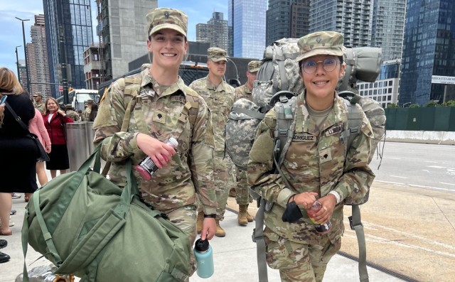 ”New York Army National Guard Spcs. Lori Gorman and Jahaira Rodriguez, both assigned to Headquarters Company of the 1st Battalion, 69th Infantry, head toward buses taking them to Fort Drum, New York, for training following a farewell event June 14, 2022, at Jacob Javits Convention Center in New York City. The Soldiers will be deploying to the Horn of Africa in September. &#34;

