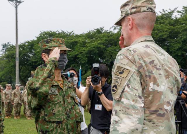 Maj. Gen. JB Vowell, right, commander of U.S. Army Japan, salutes a Japan Ground Self-Defense Force member during a patching ceremony at Camp Zama, Japan, June 17, 2022. U.S. Soldiers and JGSDF members donned a new patch to recognize and further strengthen their partnership.