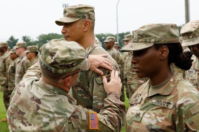 Col. Christopher L. Tomlinson, commander of U.S. Army Garrison Japan, places a new combined patch on a Soldier during a ceremony at Camp Zama, Japan, June 17, 2022. The patch, which displays both the U.S. and Japan flags, symbolizes their enduring bilateral relationship.