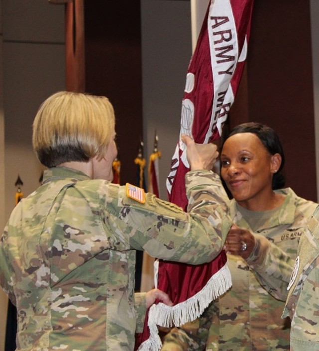Col. Wendy Gray accepts the colors on becoming the commander of Fox Army Health Center in a ceremony June 6 at Bob Jones Auditorium. In the other photo, Brig. Gen. Mary Krueger, commander of Regional Health Command-Atlantic, presents the Legion of Merit to Fox’s outgoing commander, Col. Roberto Cardenas, who led the health center since June 2020 and is retiring after 29 years of service. 