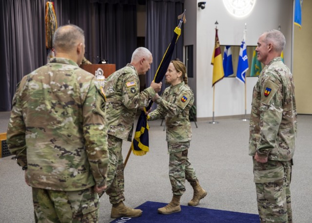 Army Col. Catherine L. Cherry receives the colors of the National Guard Professional Education Center from Lt. Gen. Jon A. Jensen, director of the Army National Guard, as she took command of the center during a change of command ceremony at the PEC’s Militia Hall at Camp Joseph T. Robinson, Arkansas, June 16, 2022. Cherry is the first woman to command the PEC, which was established as a training center in 1974.  (U.S. Army photo by Sgt. 1st Class Jim Heuston)