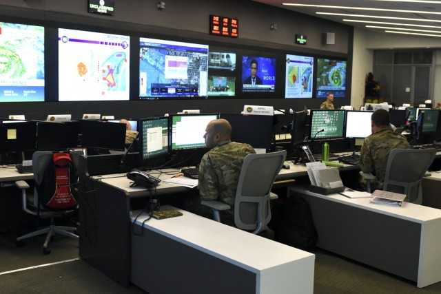 Television screens illuminate what would otherwise be a darkened underground facility at the National Guard Coordination Center, or NGCC, in Arlington, Virginia, in July 2020. In May 2022, the NGCC, along with the operations directorates of various National Guard elements, were instrumental in the delivery of the German Ministry of Defense’s SARah satellite from Baltimore to Vandenberg Space Force Base, California, for its June 18 launch into space. (National Guard Bureau photo by Master Sgt. Erich B. Smith)