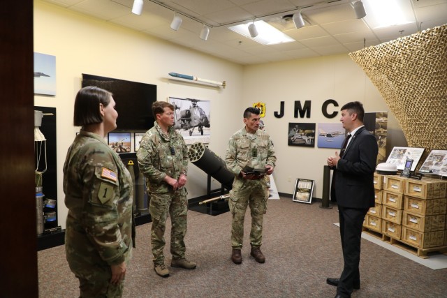 JMC Command Sergeant Major Petra Casarez (far left) and JMC Munitions Logistics and Readiness Center Director, Mr. Nate Hawley (far right) provide a tour of the JMC Display Room to Capt. Tom Walker, and Lt Col. Mark Stuart during their visit to HQ, JMC. 