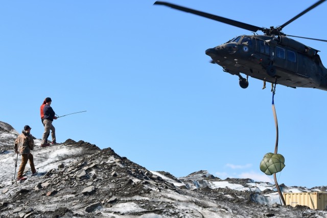 An Alaska National Guard Black Hawk helicopter brings in a container for storing recovered aircraft parts on Colony Glacier June 13, 2022, as part of the team working to recover the remains of 52 passengers and crewmembers, and wreckage of an Air Force C-124 Globemaster aircraft that crashed Nov. 22, 1952, near Mount Gannett, Alaska. Soldiers assigned to the Alaska Army National Guard discovered the debris on June 10, 2012, during a routine Black Hawk helicopter training mission on Colony Glacier nearly 14 miles from where the plane first crashed. (Army photo/John Pennell)