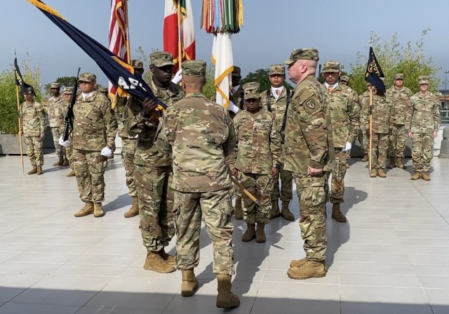 Col. Miles T. Gengler passes the Allied Forces South Battalion colors to Lt. Col. Ebrima F. M’Bai during a change of command ceremony in Lago di Patria, Italy on June 22.