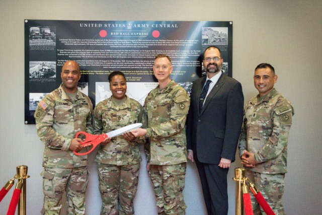 From left to right, USARCENT Commander, Lt. Gen. Ron Clark, USARCENT Logistics Operations Sergeant, Master Sgt Natasha Carroll, USARCENT Logistics Assistant Chief of Staff, Col. Joseph Kurz, Command Historian Michael Clauss, and Command Sgt. Maj J Garza pose for a photo during a ribbon cutting ceremony commemorating the reveal of the Red Ball Express monograph at Patton Hall on June 03, 2022. The Red Ball Express historical display is the latest addition to the many exhibits in Patton Hall. The monograph depicts the heroic actions of the Red Ball Express during WWII.