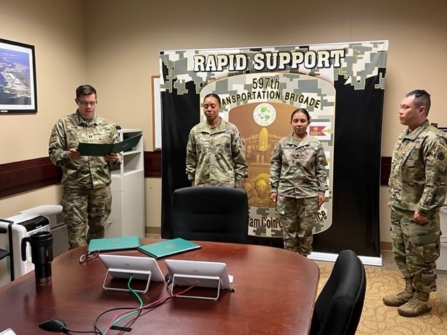Capt. Nicholas Mann reads the orders during an award ceremony that recognized Sgt. First Class Terri Francois, Brigade NCOIC/Training Readiness and Sgt. Yoana Garciarubio, S3 Training Readiness NCO, at Joint Base Langley-Eustis, Va. June 24. 