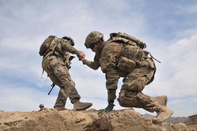 A Soldier helps a fellow Soldier onto the rooftop of a building in order to provide protective overwatch for another element of their patrol in Afghanistan Jan. 29, 2012.