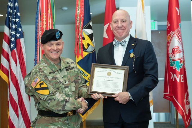 DEVCOM Commanding General Maj. Gen. Miles Brown presents John S. Willison with a Certificate of Appreciation during a retirement ceremony for Willison, who retired after 36 years of civilian service. The ceremony was held in the DEVCOM headquarters building at Aberdeen Proving Ground, Maryland.
