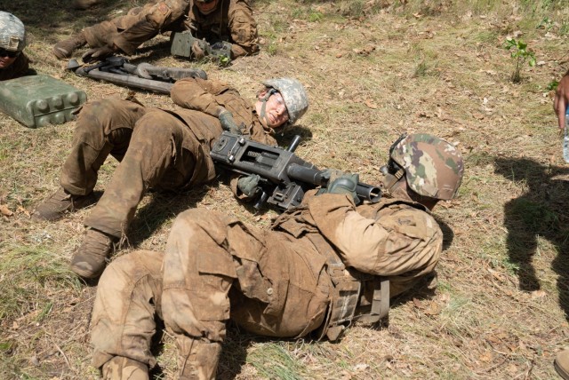 Soldiers in the Wisconsin Army National Guard’s 1st Squadron, 105th Cavalry move an MK-19 grenade launcher in a low-crawl position prior to being tested on their ability to assemble and fire the weapon as part of a voluntary qualification course...
