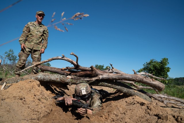 A Soldier in the Wisconsin Army National Guard’s 1st Squadron, 105th Cavalry high-crawls through the sand before being tested on a range of small arms including the M-4 rifle and grenades as part of a voluntary qualification course known as a...