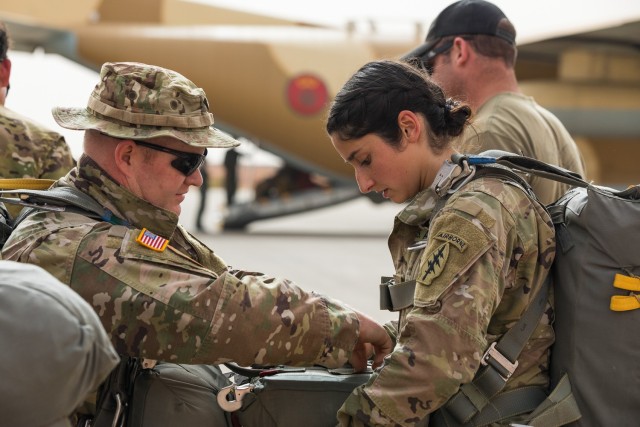 Two U.S. Army Soldiers assigned to the 19th Special Forces Group (Airborne), Utah Army National Guard, help each other attach a reserve parachute while on the tarmac of an airfield in Grier Labouihi, Morocco, waiting to board a Moroccan C-130 during an airborne operation as part of African Lion 22, June 19, 2022. African Lion 22 is U.S. Africa Command's largest, premier, joint, combined annual exercise hosted by Morocco, Ghana, Senegal, and Tunisia, June 6 - 30. More than 7,500 participants from 28 nations and NATO train together with a focus on enhancing readiness for U.S. and partner-nation forces. AL22 is a joint all-domain, multi-component, and multinational exercise, employing a full array of mission capabilities with the goal to strengthen interoperability among participants and set the theater for strategic access. (U.S. Army National Guard photo by Spc. Mackenzie Willden)