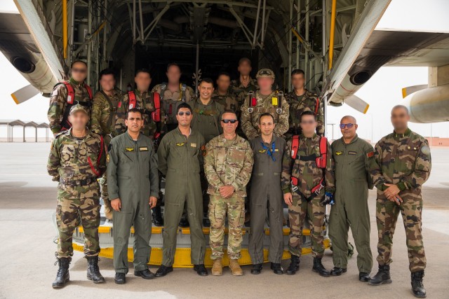 U.S. Army Maj. Gen. Andrew M. Rohling, commander of Southern European Task Force, Africa, accompanied by Soldiers assigned to the 19th Special Forces Group (Airborne), Utah Army National Guard, and Royal Moroccan Army soldiers stand at the back of a Moroccan C-130 for a group photo during the friendship airborne operation in Grier Labouihi, Morocco, as part of African Lion 22, June 19, 2022. African Lion 22 is U.S. Africa Command's largest, premier, joint, combined annual exercise hosted by Morocco, Ghana, Senegal, and Tunisia, June 6 - 30. More than 7,500 participants from 28 nations and NATO train together with a focus on enhancing readiness for U.S. and partner-nation forces. AL22 is a joint all-domain, multi-component, and multinational exercise, employing a full array of mission capabilities with the goal to strengthen interoperability among participants and set the theater for strategic access. (U.S. Army National Guard photo by Spc. Mackenzie Willden)