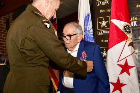 The Chief of Staff of the Army, Gen. James C. McConville, pins the Prisoner of War medal on World War II veteran, Pfc. William Kellerman, during a medals presentation ceremony at Fort Hamilton, N.Y., June 28, 2022.  Kellerman was assigned to Company D, 1st Battalion, 315th Infantry Regiment when he landed on Utah Beach, Normandy nearly 78 years ago on June 11, 1944. Less than one month into his tour of duty, the company radio was damaged under heavy gunfire and Kellerman was sent to notify his battalion’s headquarters. While en route, he was captured and taken prisoner by German soldiers on July 4, 1944. He later escaped and traveled over 600 miles before being found by the French Resistance, who hid him in the Freteval Forest until it was liberated by American forces in August 1944.  He returned to his unit and in April 1945, Kellerman’s unit engaged in combat against the Armed Forces of Germany, and he was shot in the hand and leg by enemy small arms fire. Due to his heroic achievement and service, Kellerman is entitled to wear the Prisoner of War, Purple Heart, and Bronze Star medals. (U.S. Army photo by Sgt. 1st Class Joseph Moore)