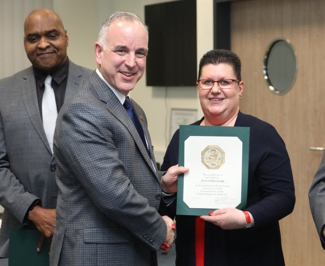 Jutta Williams receives her certificate for 40 years of federal service from former IMCOM-Europe director Michael D. Formica. 