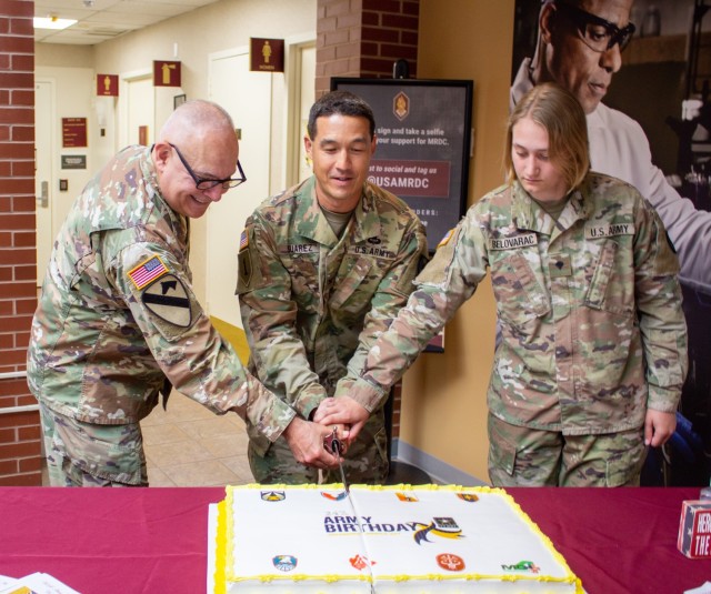 The 6th Medical Logistics Management Center Commander Lt. Col. Victor Suarez joins the youngest Soldier assigned to Fort Detrick, Spc. Katherine Belovarac (right), and the oldest Soldier, Col. Fernando Guerena, as they cut the Army’s birthday cake, June 14. This year the Army turns 247 years old.  