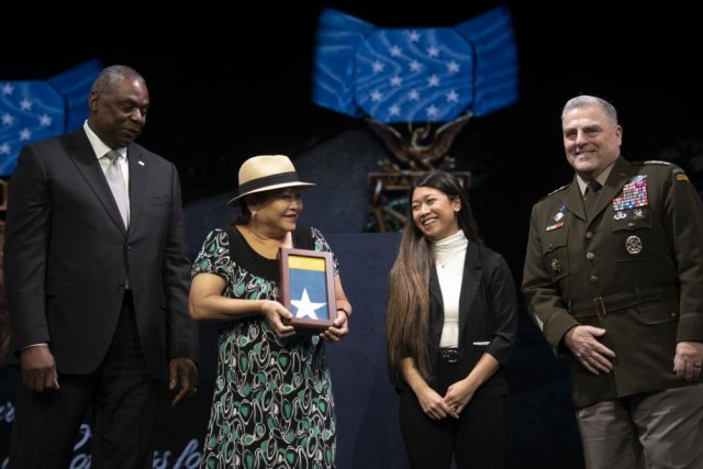 Secretary of Defense Lloyd J. Austin presents the Medal of Honor flag to Ashley Aczon-Skjelstad, the daughter of the late Medal of Honor recipient Army Staff Sgt. Edward Kaneshiro, in a ceremony where Kaneshiro and five other Medal of Honor recipients were inducted into the Pentagon Hall of Heroes, at Joint Base Myer-Henderson Hall, Va., July 6, 2022.