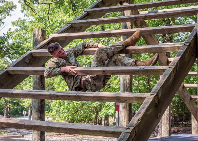 Pfc. Brayden Cooper, 763rd Ordnance Company (Explosive Ordnance Disposal), pulls himself up between the wooden planks that make up station three – called “The Weaver” – of Fort Leonard Wood’s Confidence Course July 1 at Training Area 97. Cooper is one of two EOD Soldiers from the 763rd here training for Army Air Assault School. 