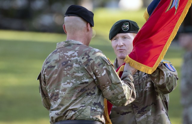 Col. Scott C. White, 193rd Infantry Brigade commander, accepts the unit colors from Brig. Gen. Patrick R. Michaelis, Fort Jackson commander, during a ceremony on Victory Field. June 30, 2022.