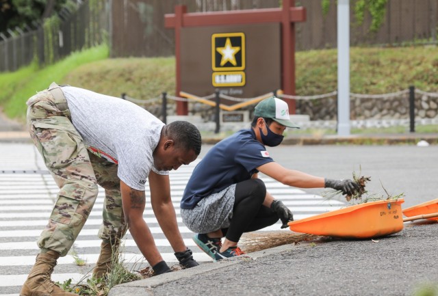 Command Sgt. Maj. Justin E. Turner, left, senior enlisted leader for U.S. Army Garrison Japan, and a member of the Japan Ground Self-Defense Force, participate in a beautification project outside the main gate of Camp Zama, Japan, July 8, 2022. More than 20 U.S. Soldiers and Japanese counterparts conducted the cleanup that also aimed to strengthen their partnership.