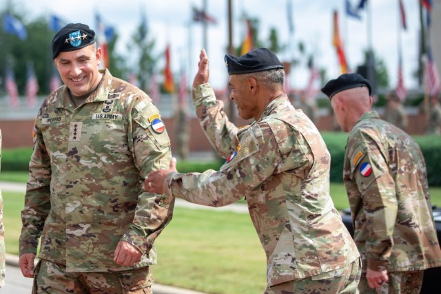 Gen. Andrew P. Poppas, U.S. Army Forces Command Commanding General, received a congratulatory pat on the back from Gen. Michael X. Garrett after assuming command of FORSCOM in a ceremony, July 8, 2022. 